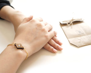 bracelet pendentif en bois porté et un packaging en kraft