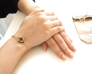 bracelet porté avec pendentif en bois et packaging en kraft
