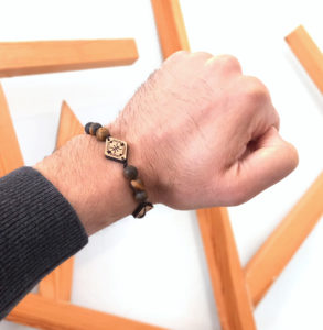 main portant un bracelets avec des perles marrons