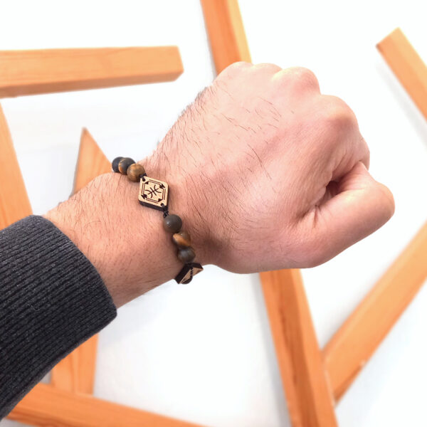 main portant un bracelets avec des perles marrons