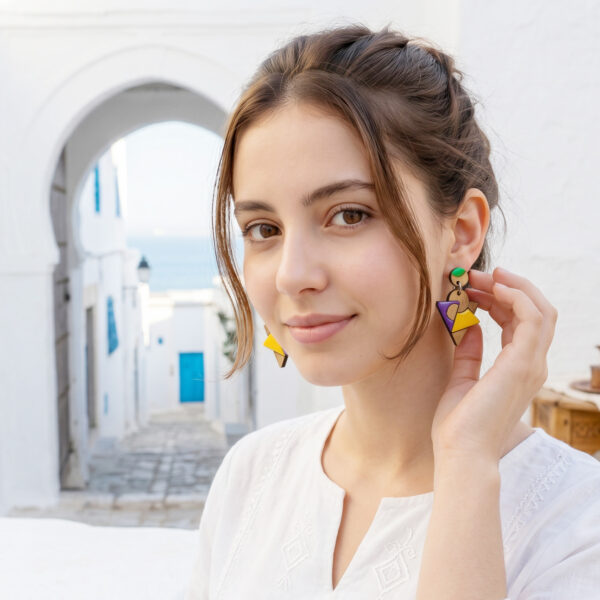 Fille brune avec boucles d'oreilles colorées dans un décors architectural et coloré