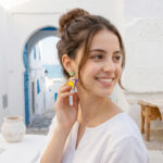 Fille brune avec boucles d'oreilles colorées