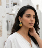 Fille brune avec boucles d'oreilles et architecture blanche