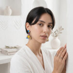 fille brune avec une boucle d'oreille en bois et décors blanc