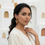Fille brune avec boucles d'oreille berbère avec habit blanc